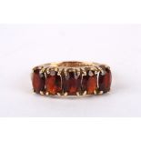 A 9ct gold and garnet five stone ring set in a plain 9ct gold mount. 2.6 grams. Ring size M.