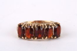 A 9ct gold and garnet five stone ring set in a plain 9ct gold mount. 2.6 grams. Ring size M.