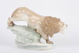 A Royal Dux style Czechoslovakian porcelain model of a lion in an aggressive pose and stood on a