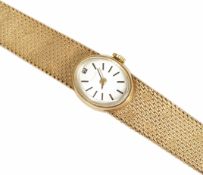 A ladies 9ct gold Tissot watch the small oval silvered dial with baton numerals, on a 9ct gold