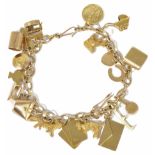 A delicate 9ct gold charm bracelet hung with a variety of charms including a Yale key, wishing well,