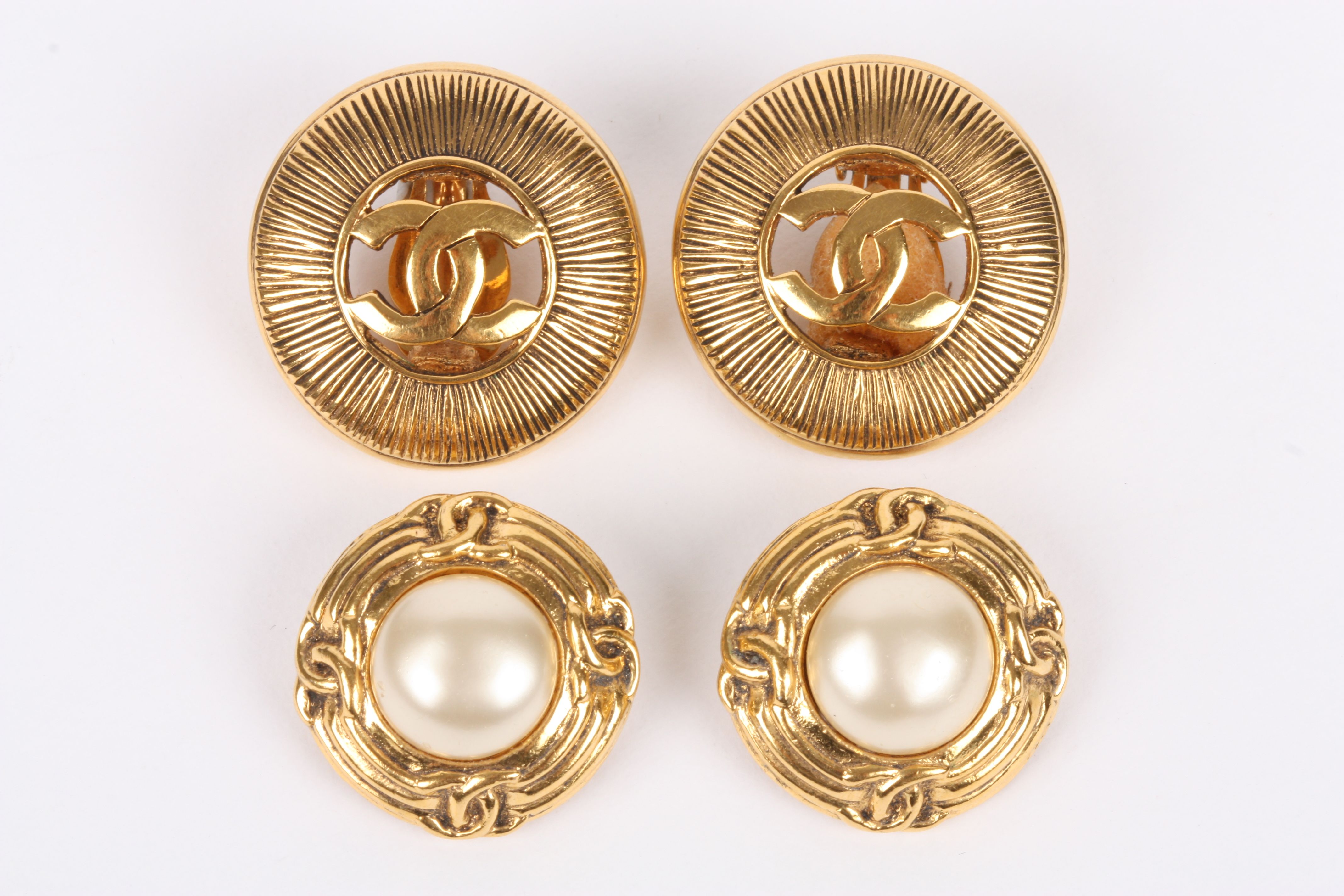 A pair of Chanel vintage clip earrings with large central pearl within a Chanel logo frame. Spring
