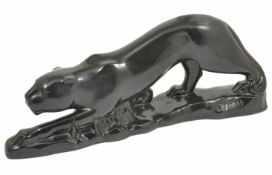 A large Art Deco style pottery black panther modelled in stalking pose on shaped naturalistic base,