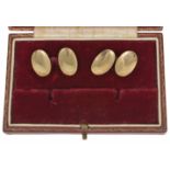 A pair of Art Deco 9ct gold cufflinks of oval convex form and linked with chains