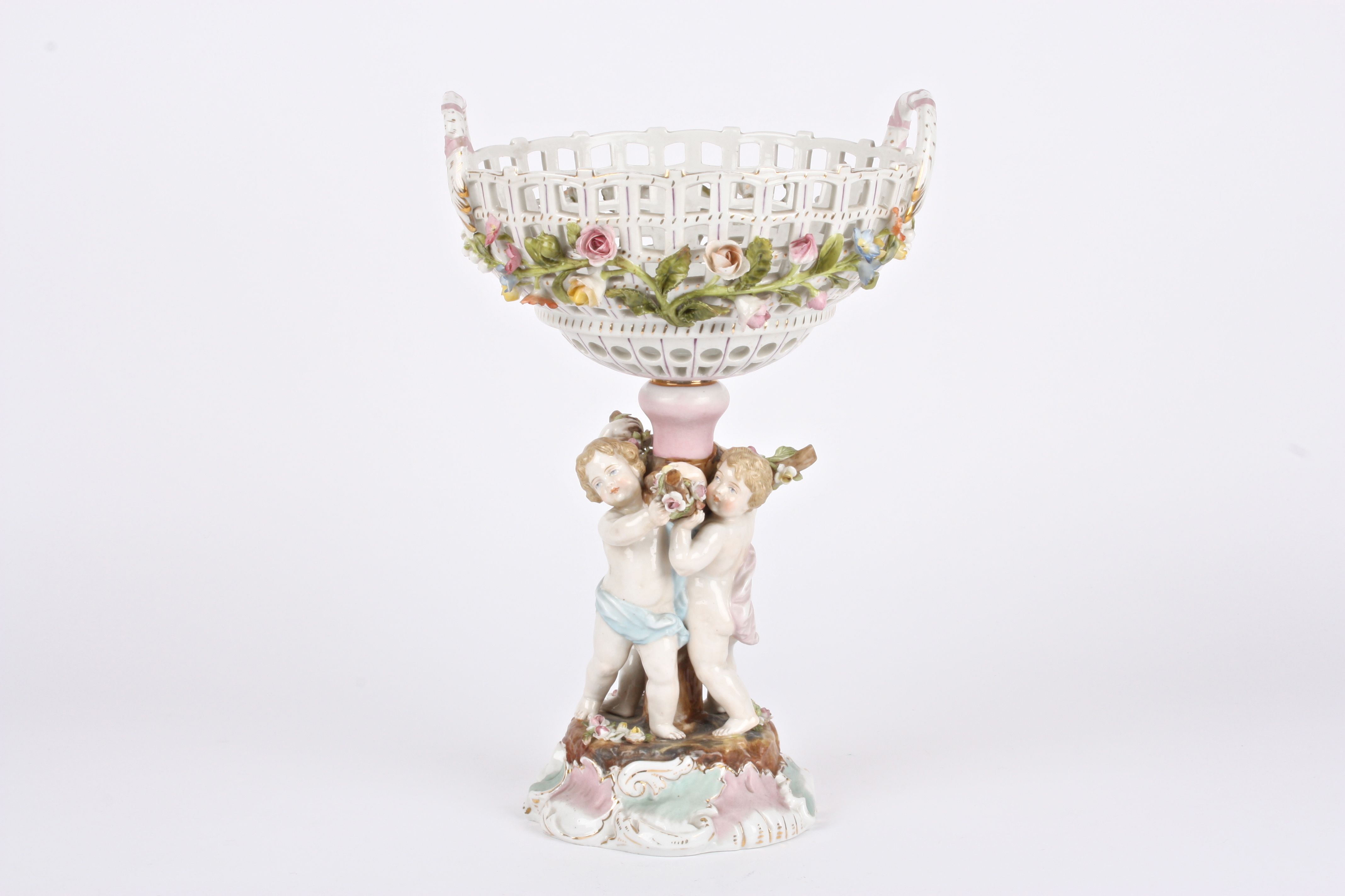 A 19th century Continental porcelain table centrepiece basket held aloft by three cherubs holding