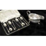 A silver sauce boat hallmarked London 1935, together with a cased set of apostle spoons and