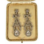 A pair of early 20th century paste set ribbon drop earrings with bow tops and pear shaped cluster