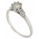 A platinum mounted diamond ring with central brilliant of approximately 0.50 in weight flanked on