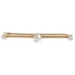 An Edwardian diamond set bar brooch with an oval old cut diamond to centre, flanked by single