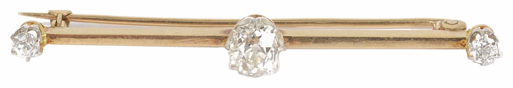 An Edwardian diamond set bar brooch with an oval old cut diamond to centre, flanked by single