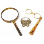 A pair of faux tortoiseshell lorgnettes together with a horn magnifier, and a decorative hand held