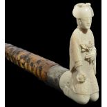 An early 20th century Japanese ivory walking stick with carved ivory handle of a geisha girl in a