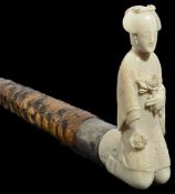 An early 20th century Japanese ivory walking stick with carved ivory handle of a geisha girl in a