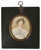 An early 19th century miniature on ivory of a young girl wearing a blue and white dress with