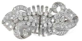 A good diamond set double clip cocktail brooch,of stylised ribbon scroll design forming a bow when