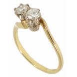 A delicate two stone diamond set cross over ring, yellow metal mount (tests gold). Stones approx.