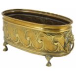 A small brass jardiniere of oval form with embossed design of stylised scrolls, and lions head