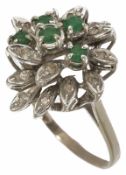 An emerald and diamond set floral cluster cocktail ring, circa 1970 with 5 central emeralds within a