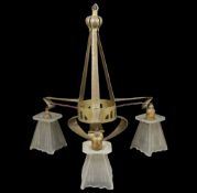 An Arts and Crafts triple hanging light with metal hanging body fitted with three glass shades