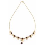 A contemporary 9ct gold garnet and pearl set drop necklace of seasonal stylised foliate scroll