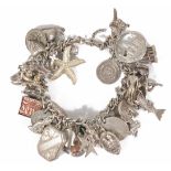 A heavy silver charm bracelet with an interesting assortment of charms including a penguin, a