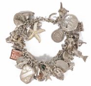 A heavy silver charm bracelet with an interesting assortment of charms including a penguin, a