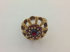 A contemporary 9ct gold garnet set ring with textured finish and floral cluster design size