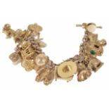 A 9ct gold charm bracelet with a rose gold chain and numerous charms, including cased solitaire