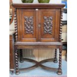 HEAVILY CARVED ANTIQUE OAK TWO DOOR CABINET WITH BARLEY TWIST SUPPORTS AND FRUIT AND VINE
