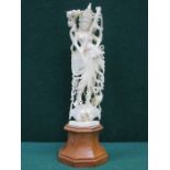 HEAVILY CARVED IVORY PIERCEWORK DECORATED FIGURE ON WOODEN STAND,