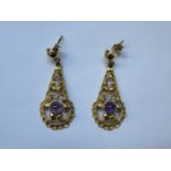 PAIR OF UNHALLMARKED GOLD COLOURED PIERCEWORK DECORATED DROP EARRINGS SET WITH PURPLE STONE