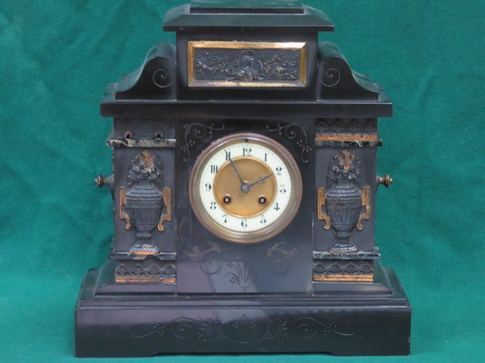 GILDED AND RELIEF DECORATED BLACK SLATE MANTEL CLOCK WITH ENAMELLED DIAL