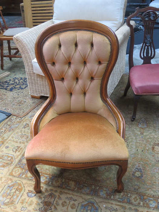 LIGHT OAK CROWN BACK UPHOLSTERED NURSING CHAIR ON BALL AND CLAW SUPPORTS.