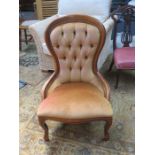 LIGHT OAK CROWN BACK UPHOLSTERED NURSING CHAIR ON BALL AND CLAW SUPPORTS.
