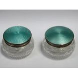 PAIR OF CUT GLASS DRESSING JARS WITH HALLMARKED SILVER AND GILLOUCHE ENAMELLED COVERS,