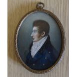 A framed portrait miniature portrait of a gentleman wearing a jacket with brass buttons and a high