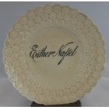 A circular child's plate 19th century, with triple moulded daisy border, the centre painted in black