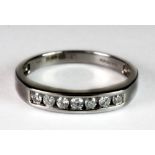 An 18ct white gold channel set 7 stone diamond ring (N.5).