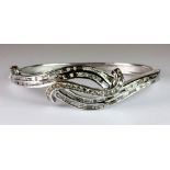 A superb 18ct white gold bangle lavishly set with baguette and brilliant cut diamonds. Est. £2,400 -