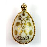 A Faberge style gilt porcelain egg pendant, L. 3.5cm.