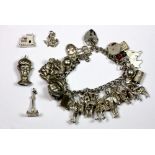 A heavy silver charm bracelet and four loose charms.