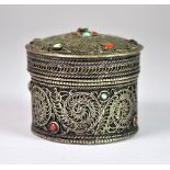 An antique Tibetan white metal box inset with turquoise and coral, H. 4cm, Dia 4.3cm.