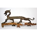 A Chinese bronze figure of a dragon on a wooden base, L. 36cm (overall), H. 17.5cm.