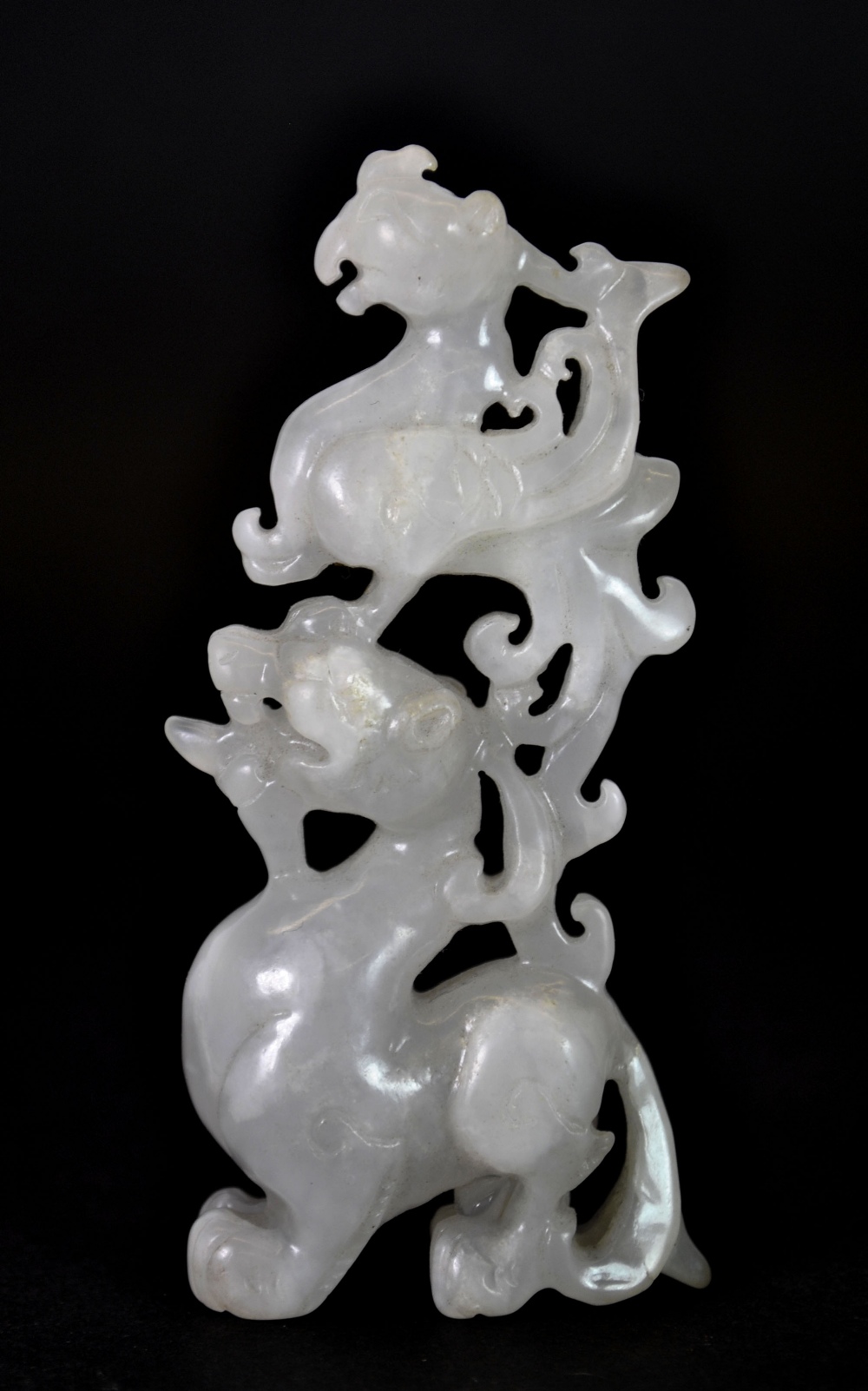 A very finely carved 19th/early 20thC Chinese white jade figure of a phoenix sitting on a dragons