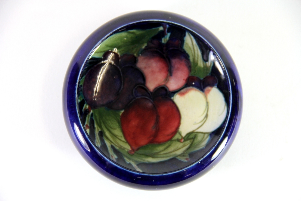 A William Moorcroft pottery 'Wisteria' circular shallow rimmed dish, with impressed factory marks to