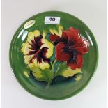 A Moorcroft 'Hibiscus' design plate, Dia. 22cm. Excellent condition.
