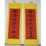 A pair of silk mounted Chinese hand painted calligraphy scrolls with gold leaf highlights, W. 51cm.