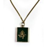 A 14ct yellow gold Chinese pendant set with jade (L. 2cm) on a 14ct yellow gold chain.