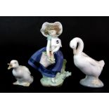 A Lladro figure of a girl and two Nao geese.