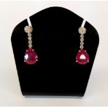 An stunning pair of 18ct yellow gold (stamped 750) drop earrings set with pear shaped rubies (